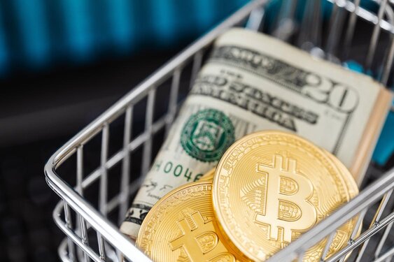 A shopping cart containing rolled-up U.S. dollar bills and a few Bitcoin coins, showcasing options to acquire Bitcoin without ID verification.